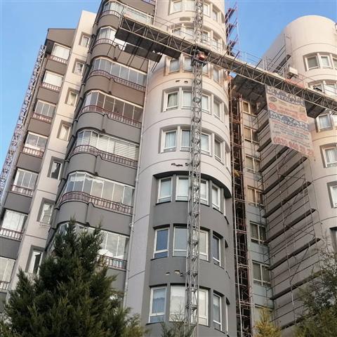 Yüksek katlı binada dış cephe mantolama — cephe asansörü ile çalışma
